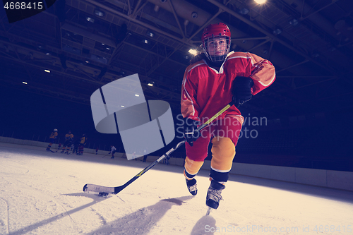 Image of teen ice hockey player in action