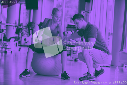 Image of young sporty woman with trainer exercise weights lifting