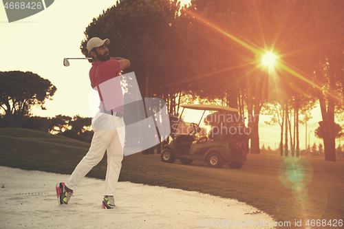 Image of golfer hitting a sand bunker shot on sunset