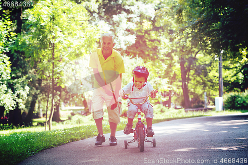 Image of grandfather and child have fun  in park