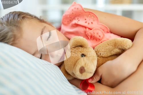 Image of little girl sleeping with teddy bear toy at home