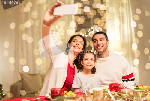 Image of happy family taking selfie at christmas dinner