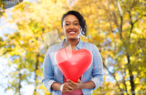 Image of african american woman with heart-shaped balloon