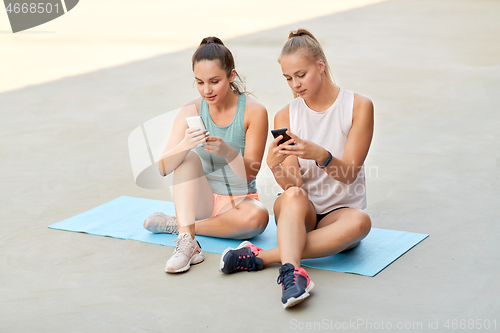 Image of sporty women or friends with smartphone on rooftop