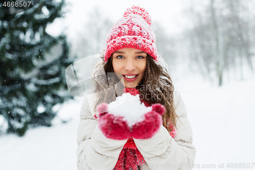 Image of portrait of young woman with snow in winter park