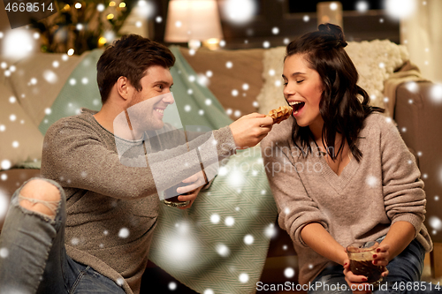 Image of happy couple eating waffles with cacao at home