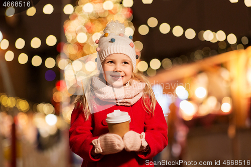 Image of happy girl with cup of tea at christmas market