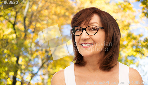 Image of portrait of senior woman in glasses in autumn