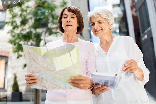 Image of senior women with city guide and map on street