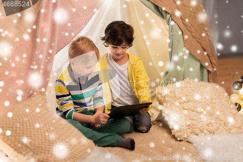 Image of little boys with tablet pc in kids tent at home