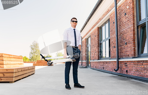 Image of businessman with folding scooter on rooftop