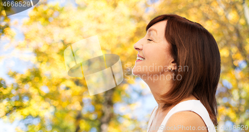 Image of profile of smiling senior woman in autumn