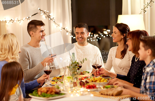 Image of happy family having dinner party at home