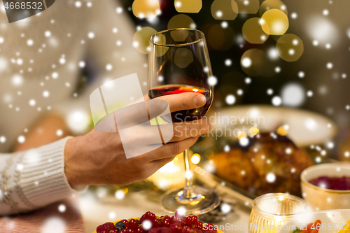 Image of close up of man drinking red wine on christmas