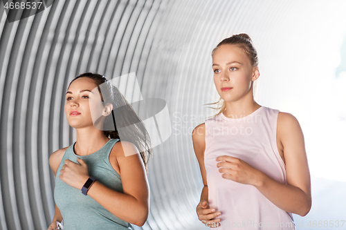 Image of young women or female friends running outdoors