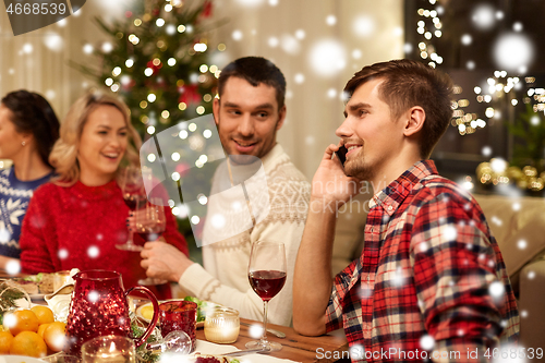 Image of man calling on smartphone at christmas dinner