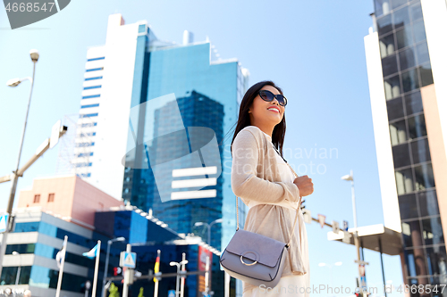 Image of happy smiling young woman on city street