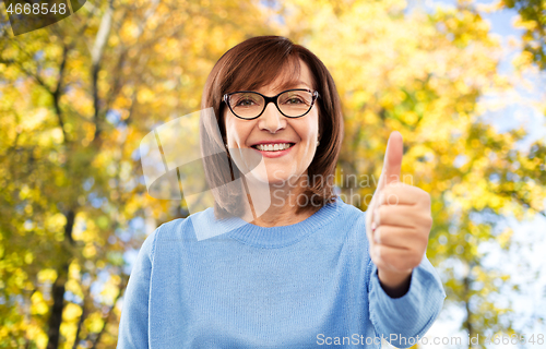 Image of portrait of senior woman showing thumbs up