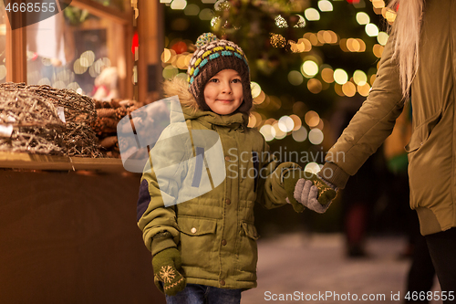 Image of happy little boy with mother at christmas market