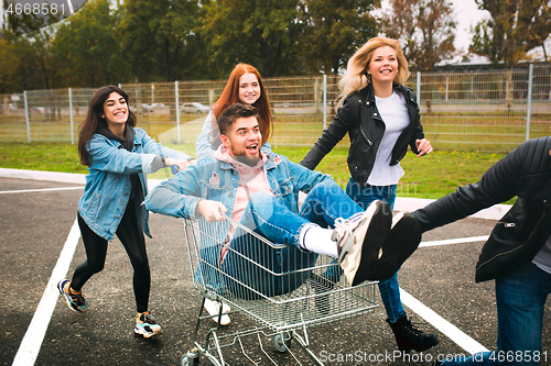 Image of Group of four young diverse friends in jeanse outfit look carefree, young and happy on city\'s streets