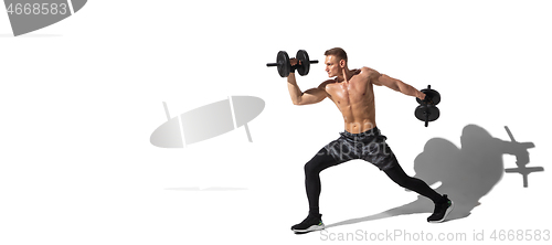 Image of Beautiful young male athlete practicing on white studio background with shadows