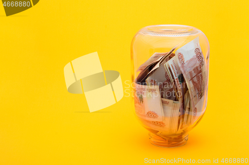 Image of In an upturned glass jar are five thousandth bills