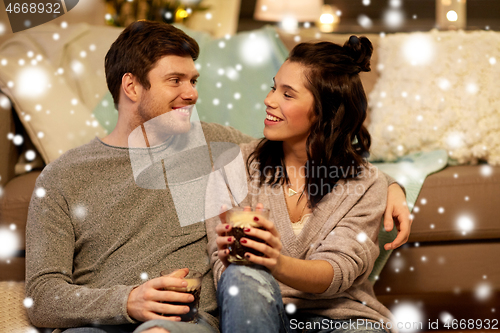 Image of happy couple drinking coffee and eating at home