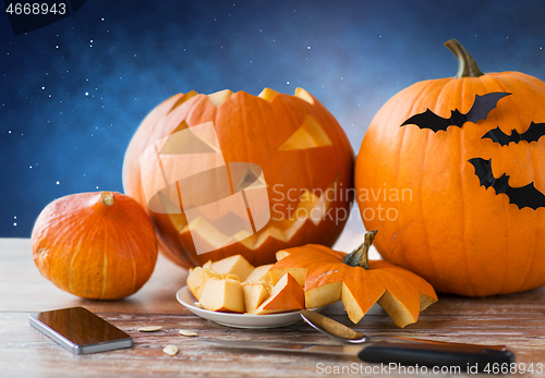 Image of halloween jack-o-lantern, pumpkins and smartphone