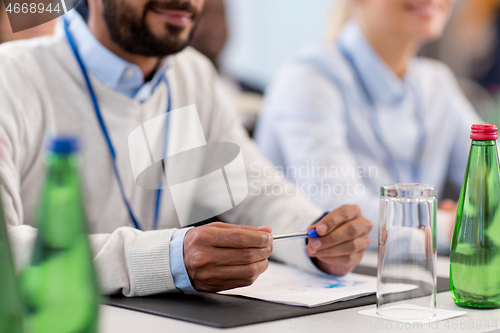 Image of businessman with papers at business conference