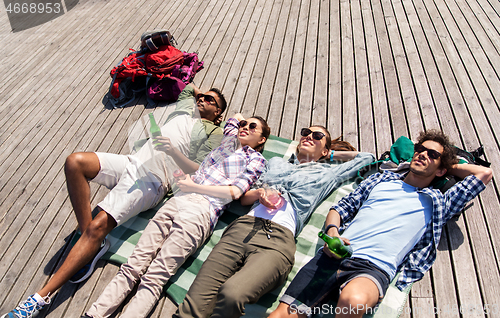 Image of friends drinking beer and cider on wooden terrace