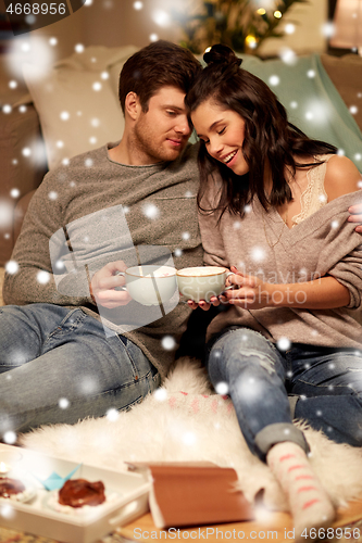 Image of happy couple drinking hot chocolate on christmas
