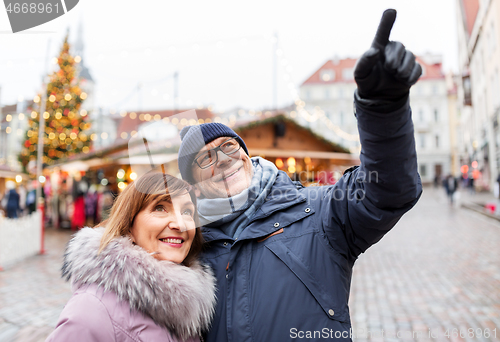 Image of happy senior couple hugging at christmas market