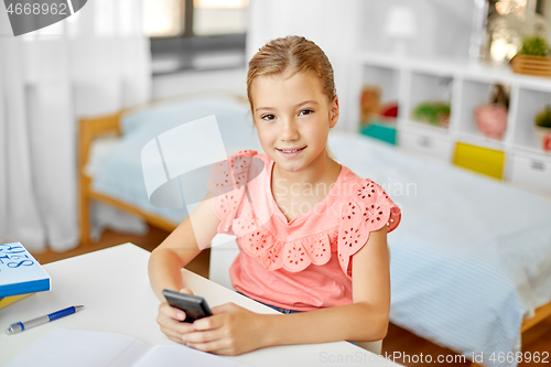 Image of happy student girl using smartphone at home