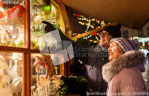 Image of happy senior couple hugging at christmas market