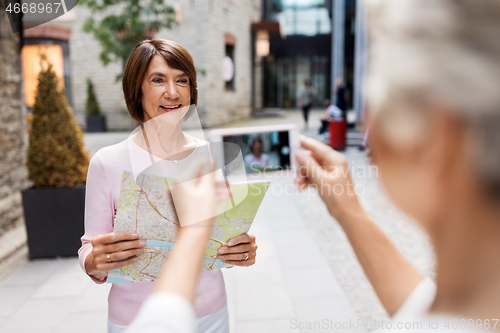 Image of senior women with city map on street in tallinn