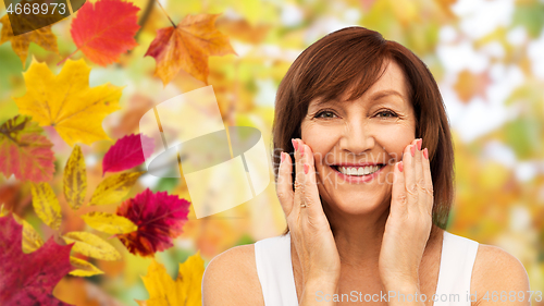 Image of portrait of smiling senior woman touching her face