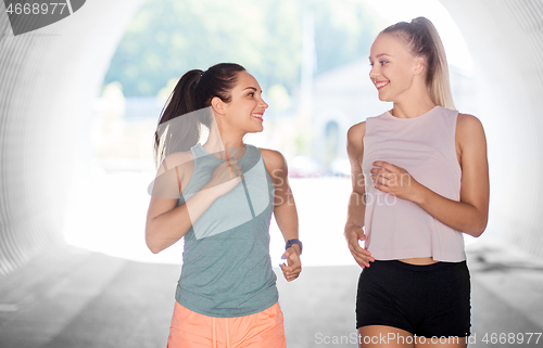 Image of young women or female friends running outdoors