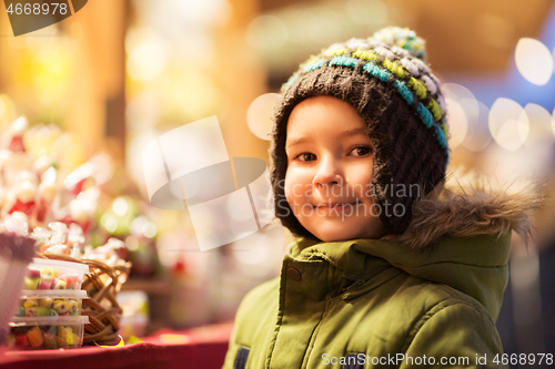 Image of happy little boy at christmas market candy shop