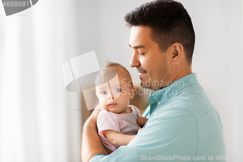 Image of middle aged father with baby daughter at home