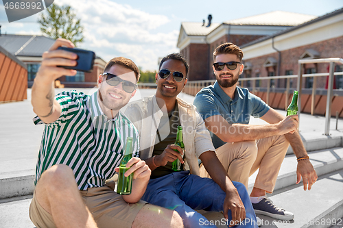 Image of men drinking beer and taking selfie by smartphone