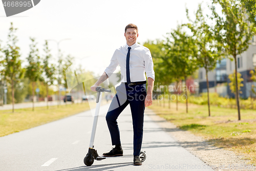 Image of young businessman with electric scooter outdoors