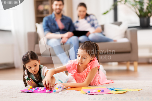 Image of happy sisters doing arts and crafts at home