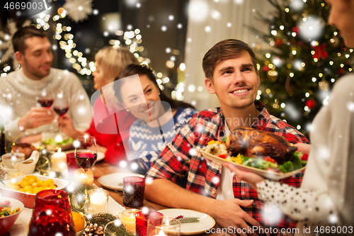 Image of happy friends having christmas dinner at home