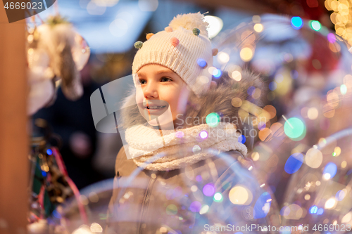 Image of happy little girl at christmas market in winter