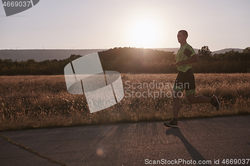 Image of triathlon athlete running on morning trainig