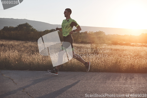 Image of triathlon athlete running on morning trainig