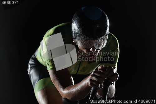 Image of triathlon athlete riding bike fast at night