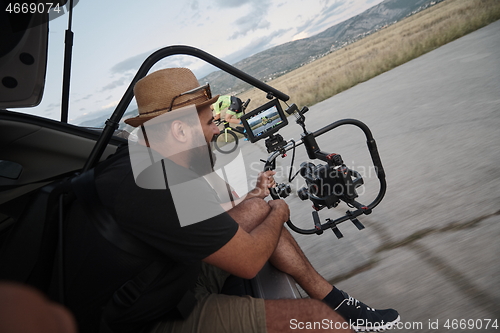 Image of videographer taking action shot of triathlon athlete while riding bike