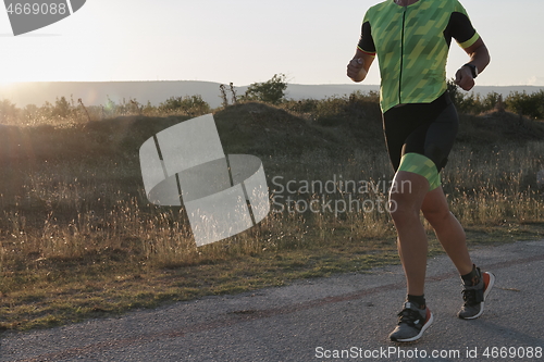 Image of triathlon athlete running on morning trainig