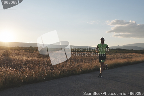 Image of triathlon athlete running on morning trainig